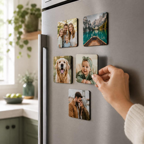 Hand placing a custom photo fridge magnet onto a fridge door in a bright kitchen